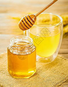 土产品木桌上的蜂蜜和蜂蜜水背景