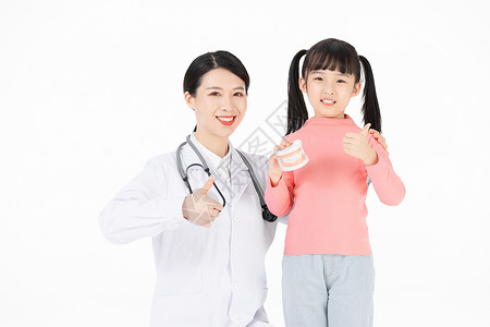 手拿牙齿模型的小女孩和牙医点赞图片