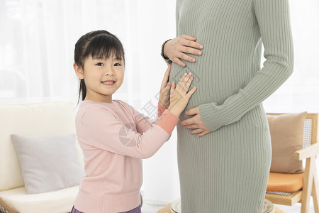 小女孩抚摸妈妈的孕肚背景图片
