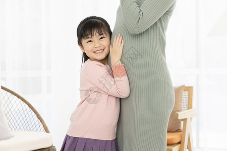 小女孩抚摸妈妈的孕肚背景图片
