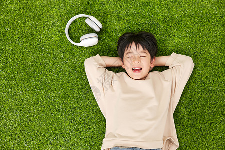 听歌的男孩躺在草坪上的小男孩背景
