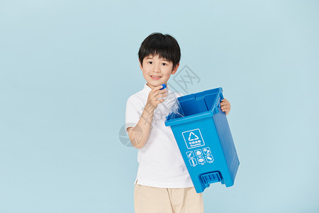 抱着可回收物垃圾桶的小男孩图片
