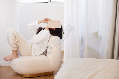 女模特脸居家女性躺在沙发上用书盖着脸背景