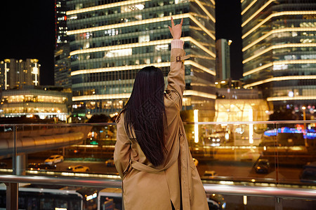 冬季夜晚都市女性人像举手欢呼高清图片