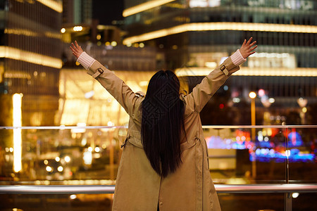 冬季夜晚都市女性人像双手举起欢呼图片