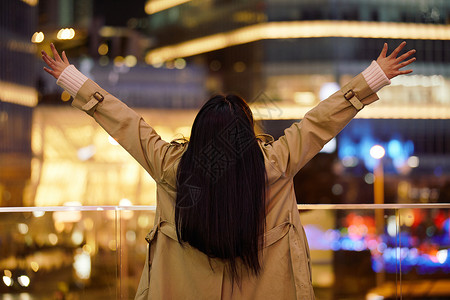 冬季夜晚都市女性人像双手举起欢呼高清图片
