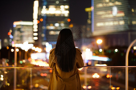 闹市区冬季夜晚都市女性人像背影背景