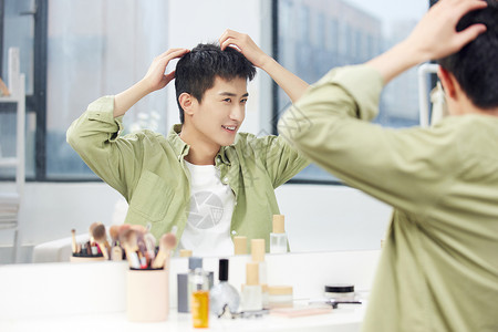 男士彩妆年轻男士镜子前整理发型背景