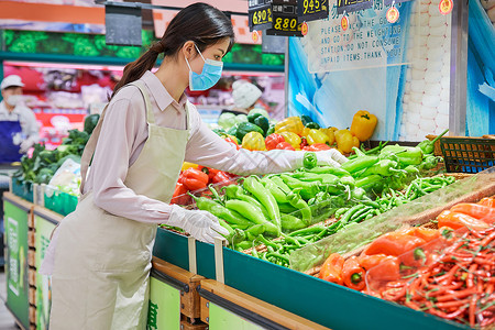 口罩佩戴示意图佩戴口罩的超市服务员整理蔬菜区背景