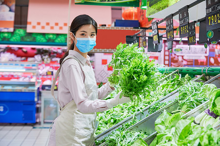 佩戴口罩的超市服务员整理蔬菜区高清图片