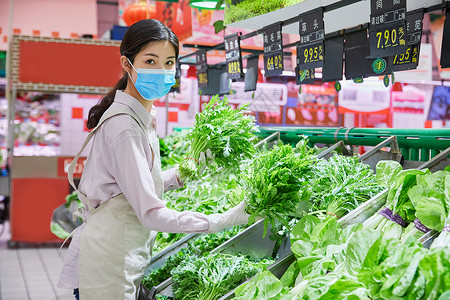 佩戴口罩的超市服务员整理蔬菜区背景图片