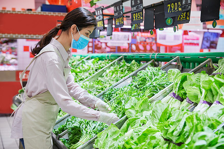 佩戴口罩的超市服务员整理蔬菜区高清图片