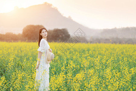 油菜花花海中的少女背景图片