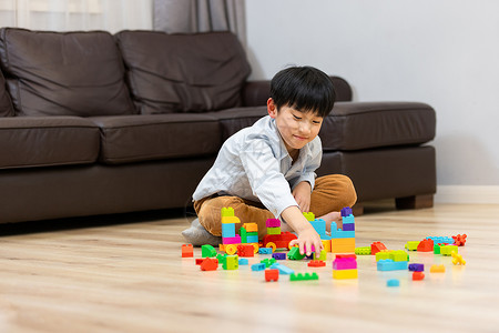 小男孩独自一人在家玩积木高清图片
