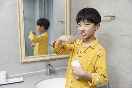 黄色护袖在浴室刷牙的小男孩背景