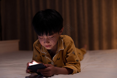 在黑夜里使用手机的小男孩图片