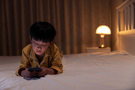 电话黑素材在黑夜里使用手机的小男孩背景