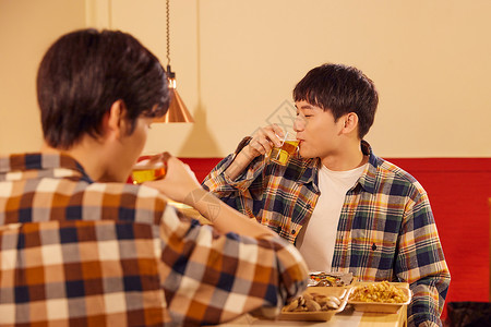 青年男性朋友欢乐喝啤酒撸串背景图片