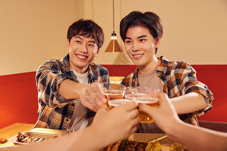 青年男性朋友欢乐喝啤酒撸串背景图片