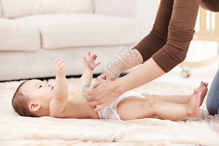 四肢麻痹母亲给婴儿宝宝伸展四肢按摩背景