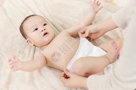 儿童纸尿裤母亲帮婴儿小宝宝穿尿不湿背景