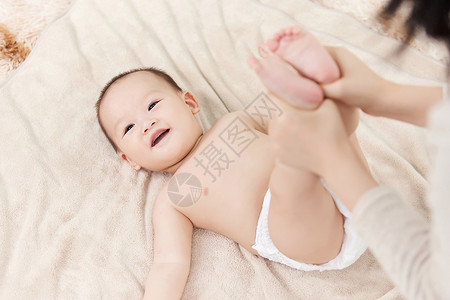 母亲给婴儿宝宝伸展四肢高清图片