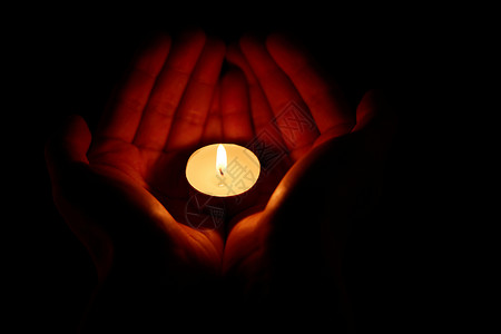 清明节缅怀抗疫烈士宣传海报祈福祝福手捧着燃烧的蜡烛背景