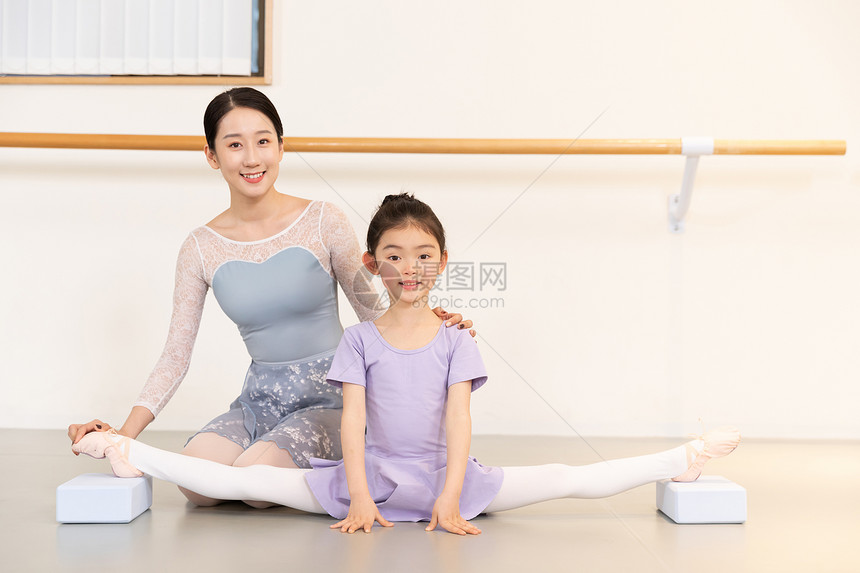 舞蹈老师帮助小女孩压腿图片