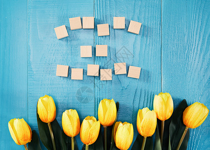 蓝色木板上放的郁金香背景图片