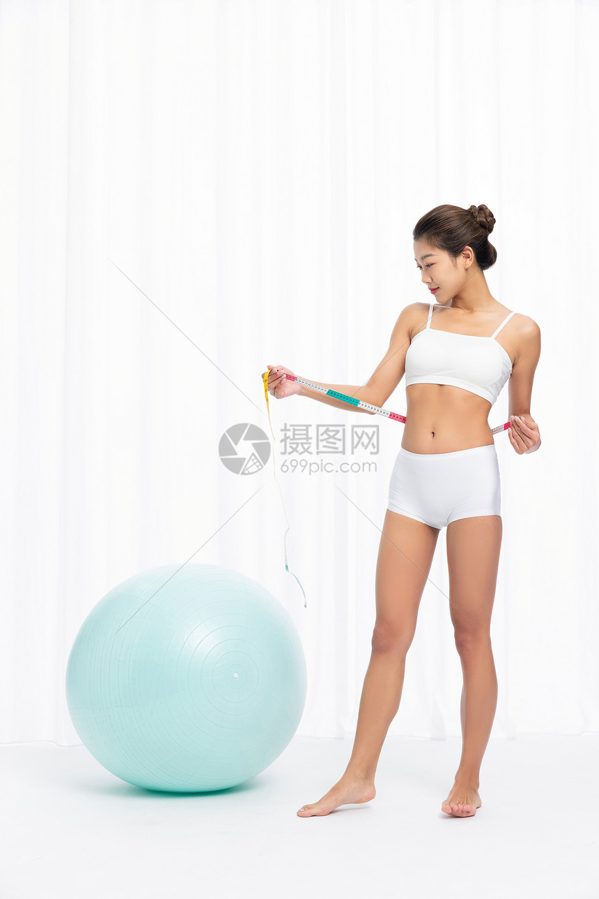 健身女性使用皮尺测量腰围图片