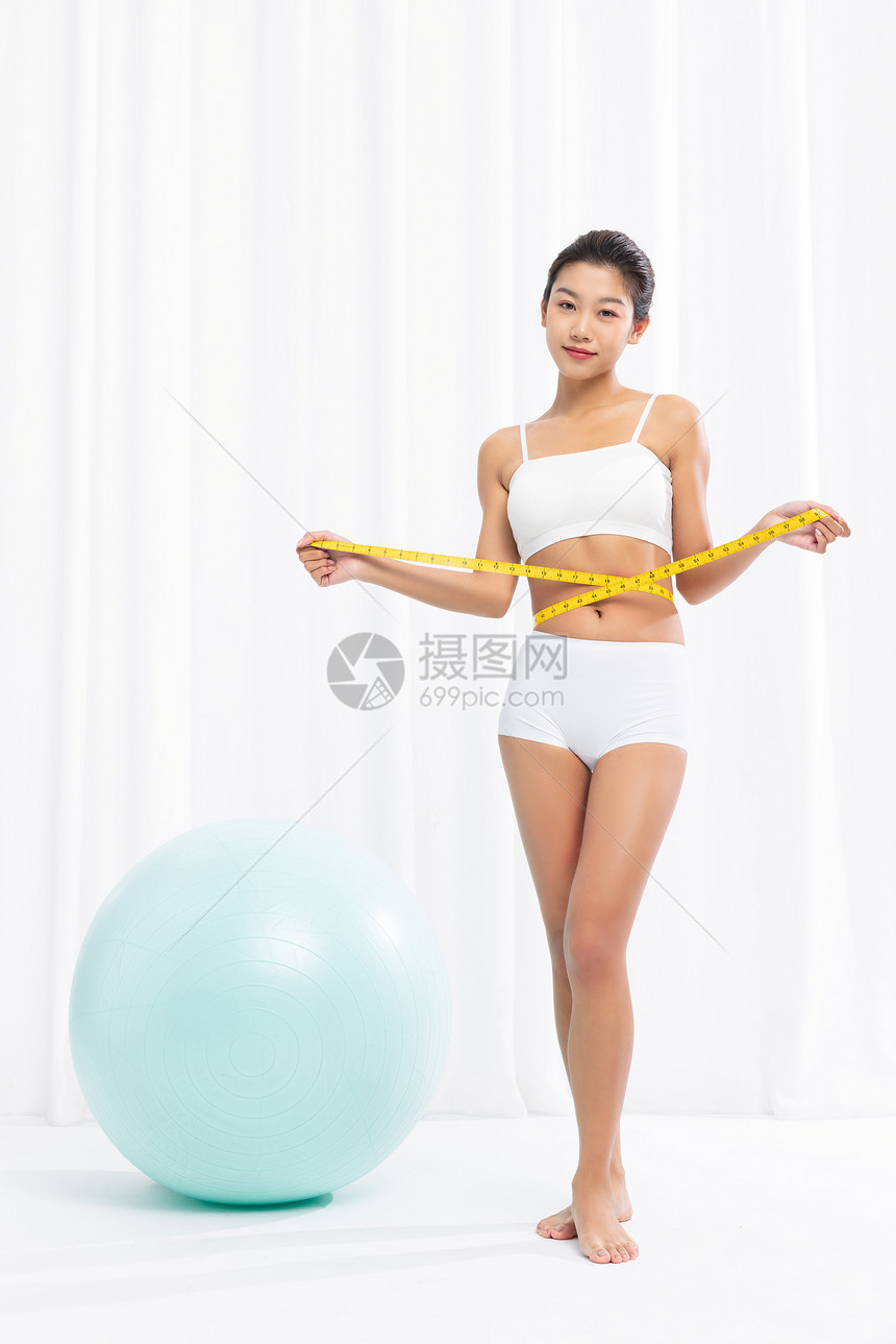 健身女性使用皮尺测量腰围图片