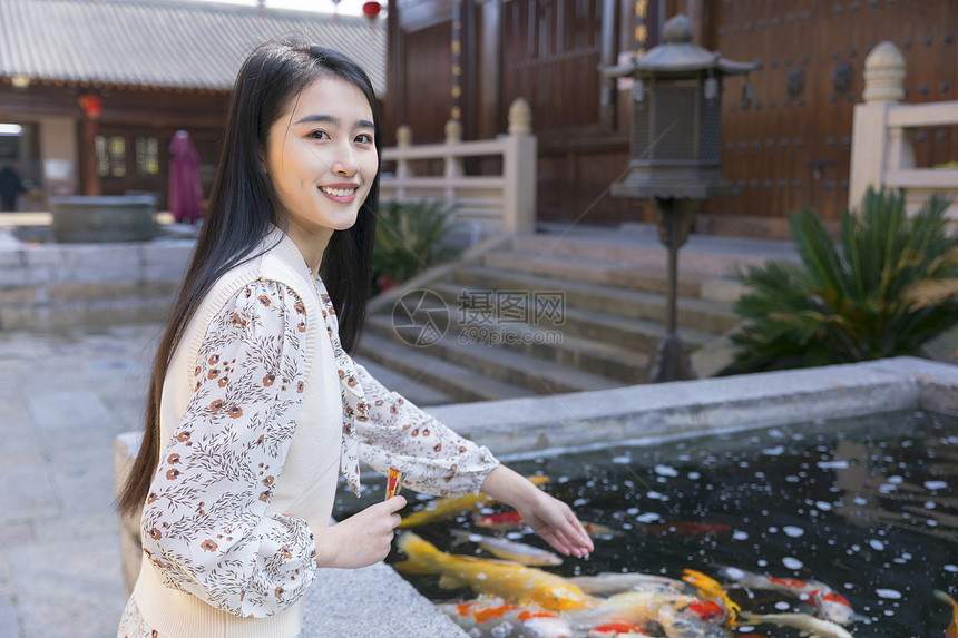 美女大学生逛寺庙喂食金鱼图片