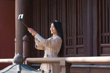 用望眼镜少女美女大学生旅行用手机拍照背景