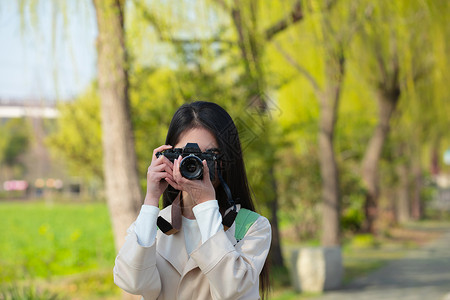 青春美女大学生背着相机旅行拍照图片