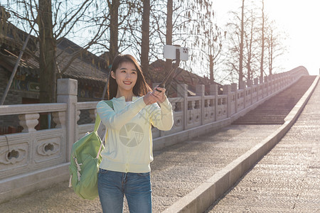 美女大学生春游拿自拍杆拍照图片