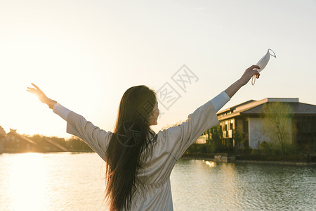 美女大学生旅行摘掉口罩背影高清图片