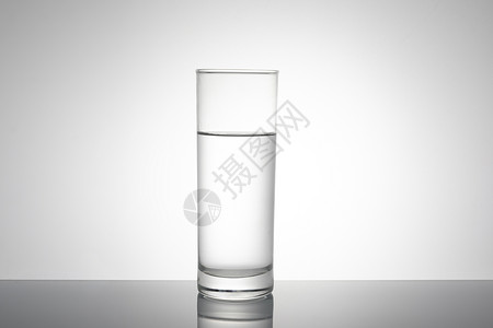 一杯白开水往杯子里倒水背景