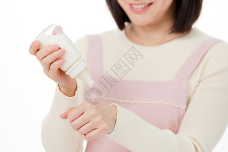 粉色奶瓶月嫂用手背测试牛奶水温背景