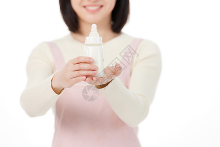 粉色奶瓶拿着奶瓶的月嫂手部特写背景