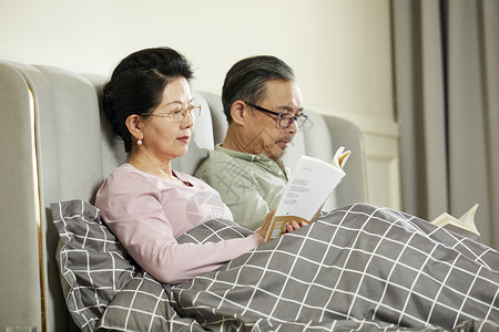 中老年夫妇坐床上阅读图片