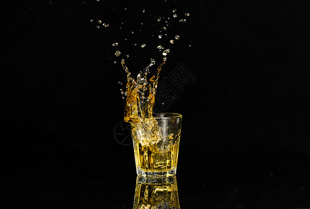 小水珠冰块落入酒杯溅起水花背景