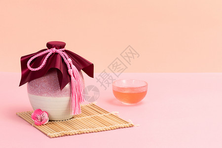 粉色背景静物酒坛子和酒杯桃花酒背景图片