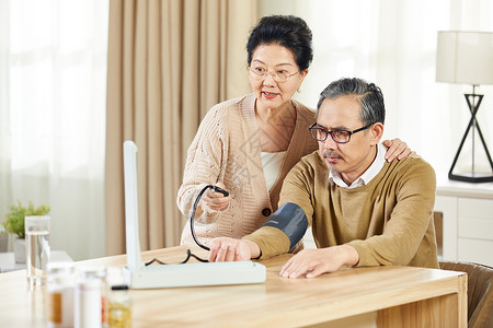 中老年女士给高血压丈夫测量血压背景图片