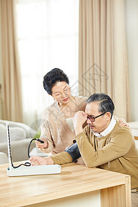 老年女士给高血压丈夫测量血压高清图片
