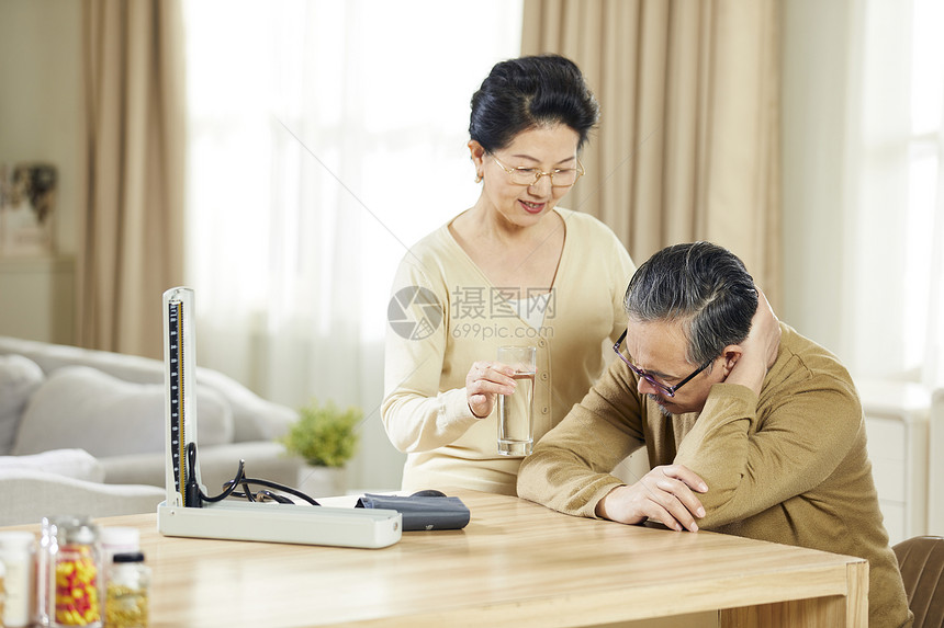 中老年女士辅助丈夫吃药图片
