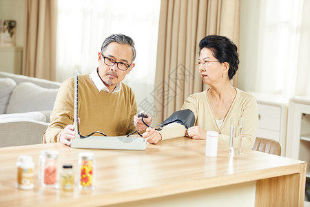 中老年夫妇居家测量血压背景图片
