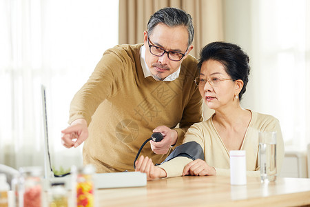 中老年夫妇居家测量血压看着血压计背景图片