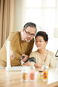 指数素材中老年夫妇居家测量血压看指数背景