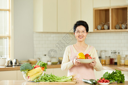 中老年女性手捧新鲜蔬菜图片