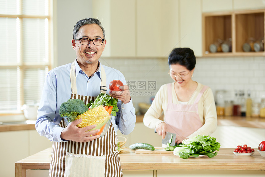厨房里中老年男士手捧新鲜蔬菜图片